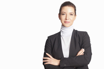 Executive mature businesswoman. A smiling middle aged woman wearing suit while standing with arms crossed and looking at camera at isolated white background.