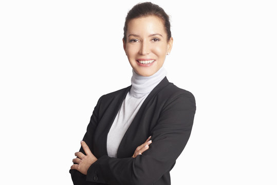 Executive mature businesswoman. A smiling middle aged woman wearing suit while standing with arms crossed and looking at camera at isolated white background.