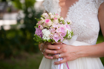 Purple and rose flowers in the bride's hand, wedding day