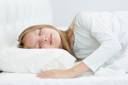 Happy teen girl sleeping in bed