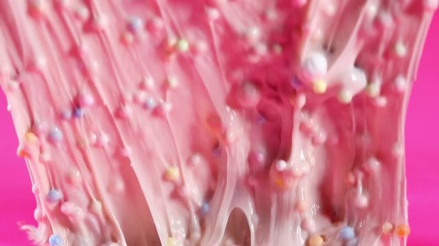 Pink, bubbly slime being stretched and played with