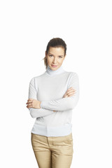 Confident mature woman. A smiling woman standing with arms crossed at isolated white background. 