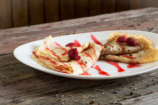 Pancakes sereved with raspberries. .On a wooden background. rustic food