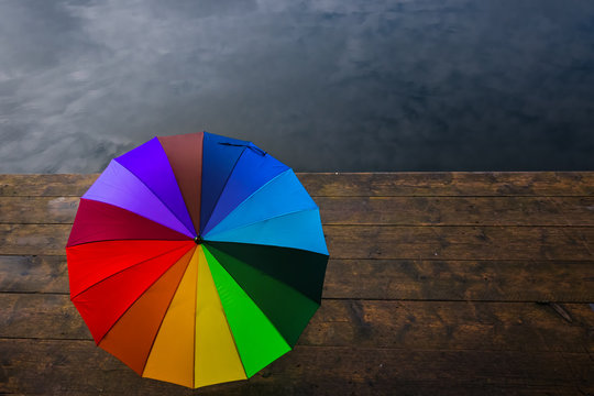 Colourful umbrella on wooden planks at a lake