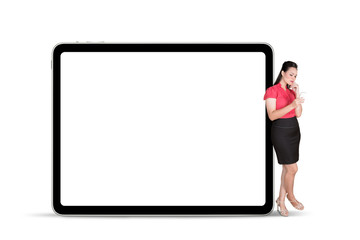 Pretty businesswoman standing with a blank tablet