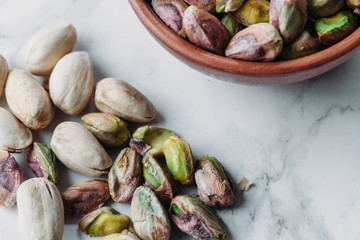 Roasted and salted pistachios nuts on marble background