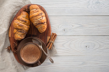 morning breakfast, composition of coffee and croissants on a wooden background