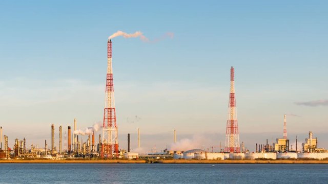 Timelapse sequence of a large oil refinery in the harbor of Antwerp, Belgium with blue sky and warm evening light.
