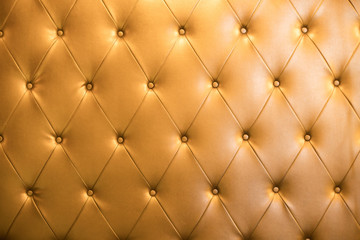 Abstract background texture of an old natural luxury gold leather sofa with rhombs