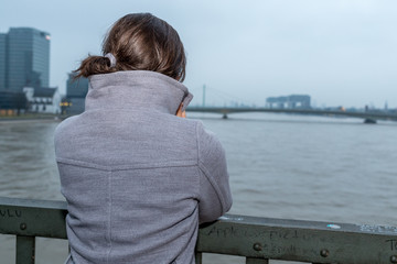 Junge Frau schaut auf den Rhein bei K&ouml;ln