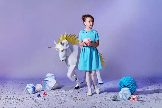 Pretty girl in an elegant blue dress for teenage girls with a make-up. Origami and minimalism. Fashion kid. Romantic little girl.