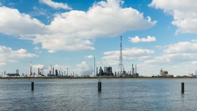 Timelapse sequence of large oil refineries in the harbor of Antwerp, Belgium with blue sky and mixed shadow and sunlight in 4K.
