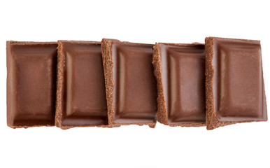 Milk chocolate pieces isolated on white background.