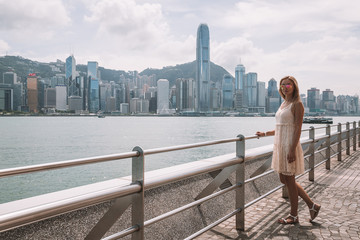 Hong Kong, China. August 30, 2017. Young girl standing on the coastline in Hong Kong watching city...