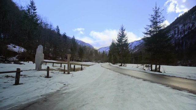 Walking towards a road in the middle of a forest, with beautiful clowds in the sky