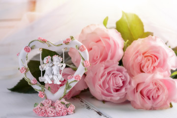Postcard to Valentine's Day: loving angels on a swing and pink roses