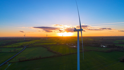 Fototapeta na wymiar Coucher de soleil sur un champ d'éoliennes près de Sainte Pazanne, en Loire Atlantique
