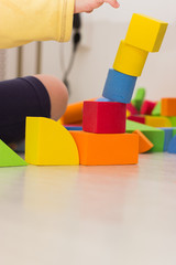 The child plays with colored cubes and puts them on each other