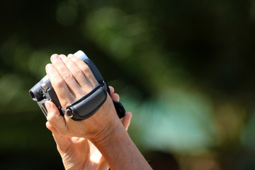 Hand-holding and control the video camera with a natural background.