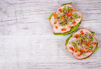 Sandwiches with lettuce, ham and broccoli sprouts.