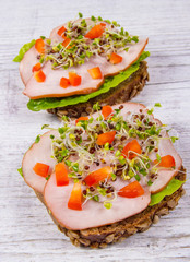 Sandwiches with lettuce, ham and broccoli sprouts.