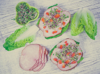 Sandwiches with lettuce, ham and broccoli sprouts.