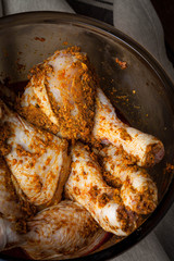 Marinated chicken drumsticks in a glass bowl.
