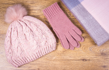 Fototapeta na wymiar Warm winter knitted clothes on a wooden background.