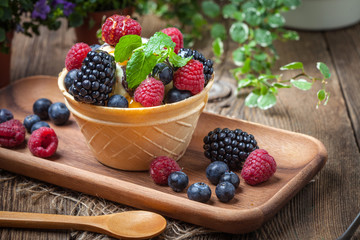 Tasty ice cream dessert with fruit in a waffle bowl.