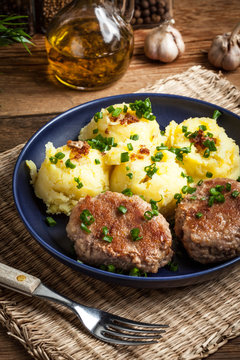 Meatballs served with boiled potatoes on a plate.