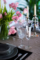  A tin table with glasses of wine and champagne with a bouquet of pink tulips