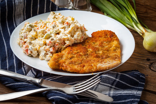 Fried pork chop in breadcrumbs, served with vegetable salad.