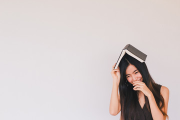 Young cute asian businesswoman holding a book and smiling with copy space - Education and back to...