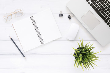 Minimal work space - Creative flat lay photo of workspace desk. Top view office desk with laptop, mock up notebooks and plant on white wooden background. Top view with copy space, flat lay photography
