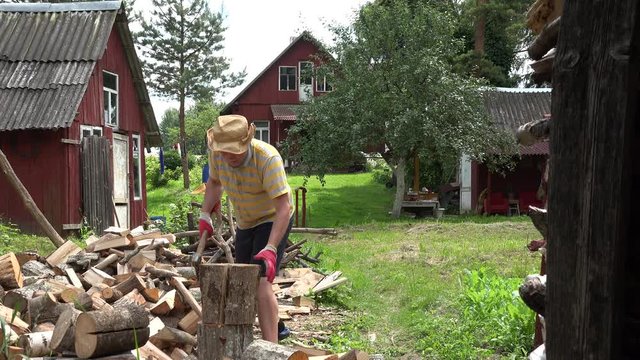 Farmer man with hat unsuccessful try to chop big wood log. 4K