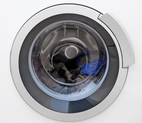 Washing machine with clothes, closeup. Laundry day