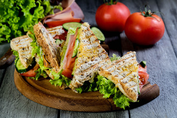 Panini sandwich with ham, tomato and lettuce.