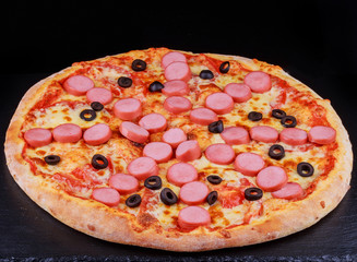 Pizza with sausages, olives, cheese and tomatoes