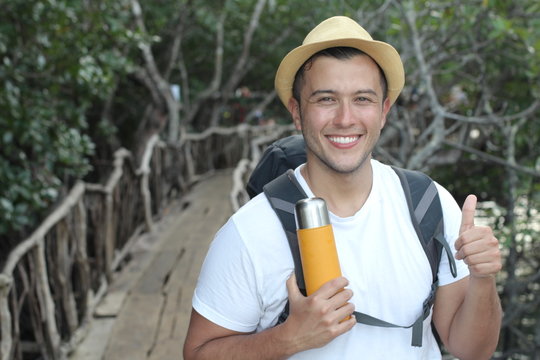 Ecstatic backpacker giving thumbs up from the jungle