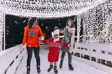 Mother with her daughter and friend enjoying in ice skating. © hedgehog94