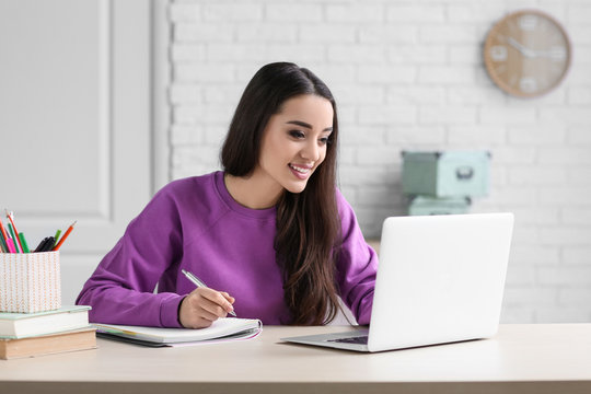Young woman using laptop indoors