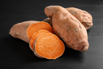 Sweet potatoes with slices on dark background