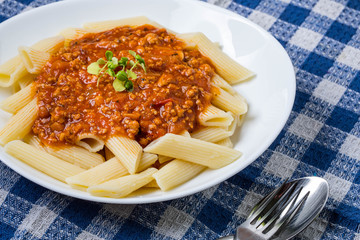 Pasta penne with tomato bolognese sauce.