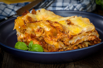 Piece of tasty hot lasagna with red wine.