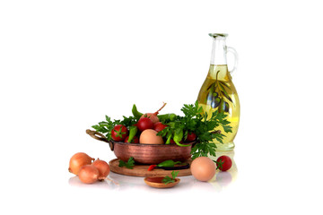 Menemen. Ingredients for cooking traditional Turkish fried eggs with tomatoes. In the frypan, olive oil, chicken eggs, ripe tomatoes, hot green peppers and spices. close-up still life.
