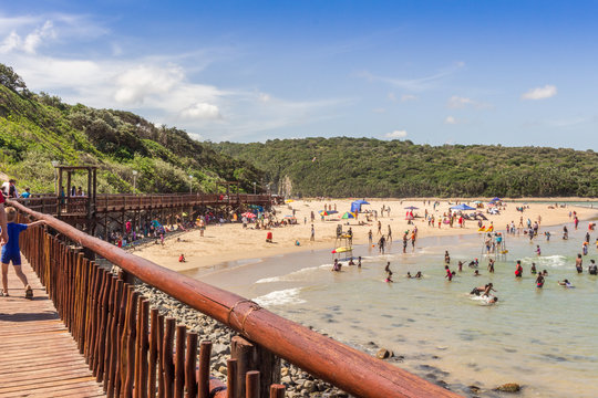 Beachgoers having fun on a hot summer day on the beach near  a boardwalk - Holiday background