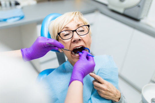 Senior woman having dental treatment at dentist's office. 