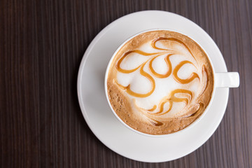 Hot latte art coffee cup on wooden table, Top view