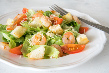 Caesar salad with shrimps, cherry tomato, croutons, salad leaf and parmesan cheese