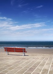 Rote Sitzbank vor blauem Meer